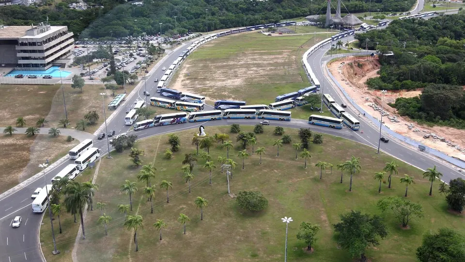 Ônibus intermunicipais novos enfileirados em pátio, com faixas e adesivos