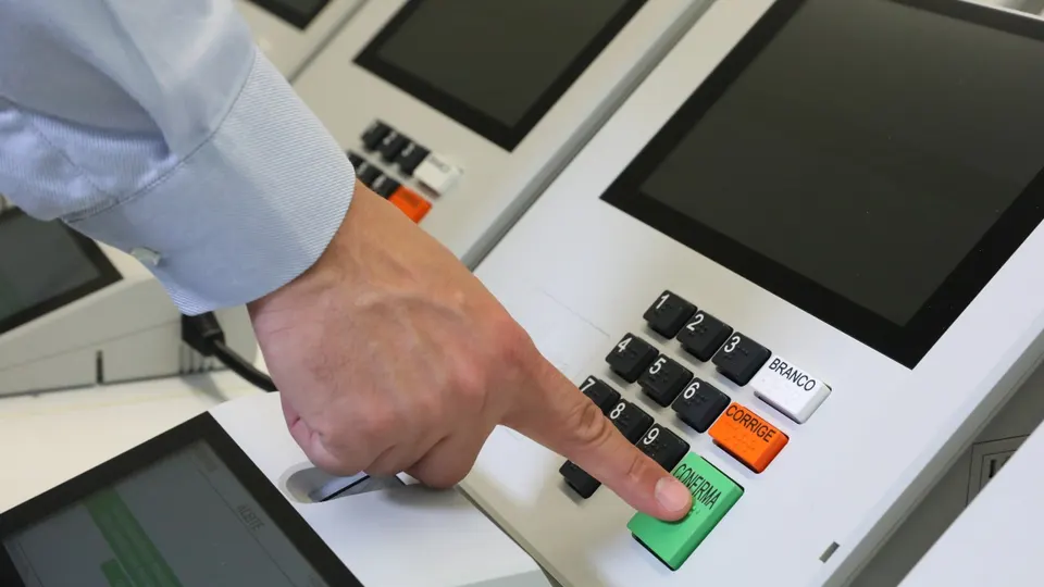 Urna eletrônica brasileira em close, com teclado numérico e tela