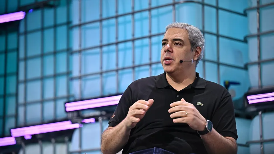 Executivo de terno no palco do Web Summit Rio 2025 falando ao público